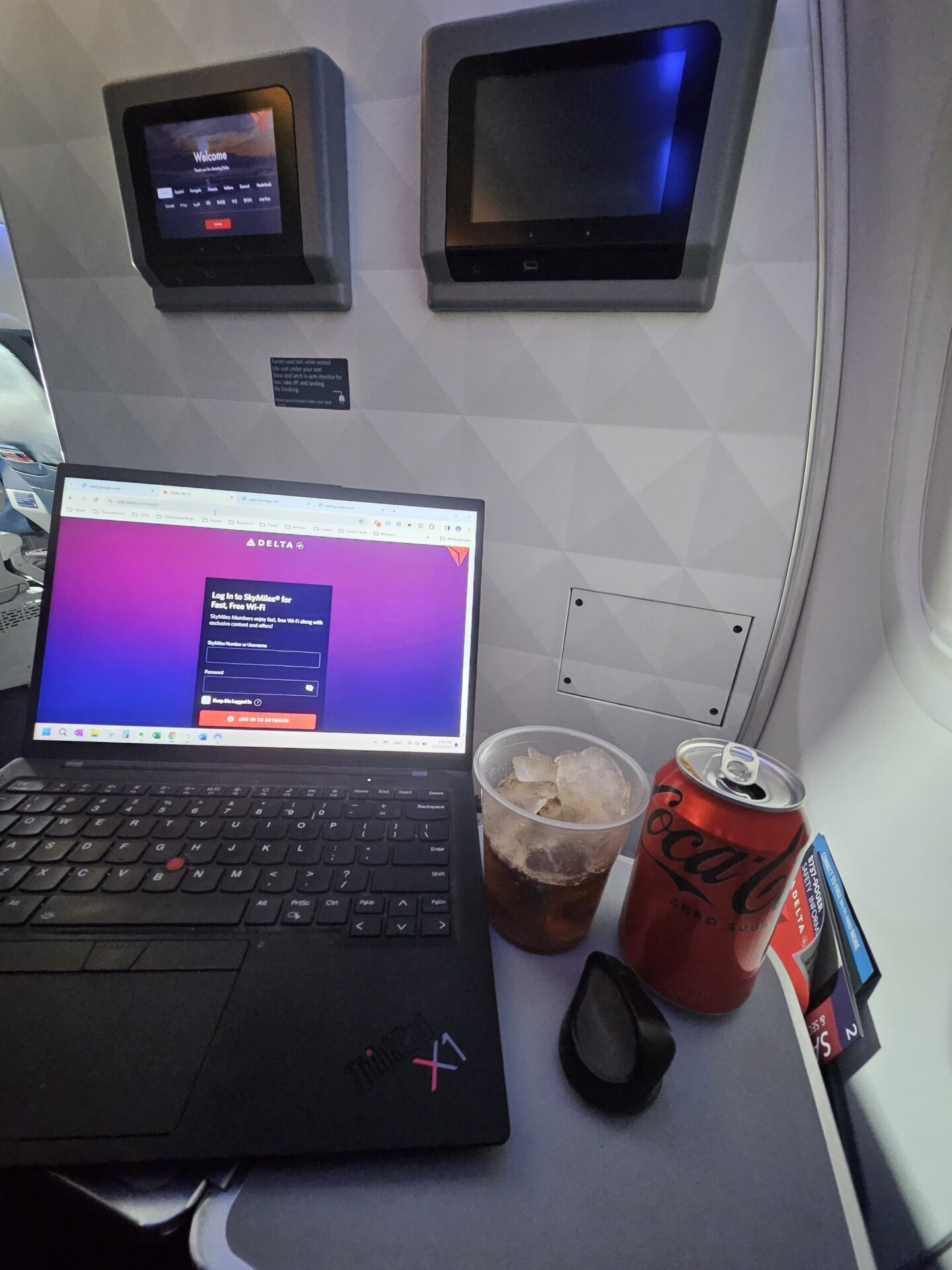 a laptop and soda on a table