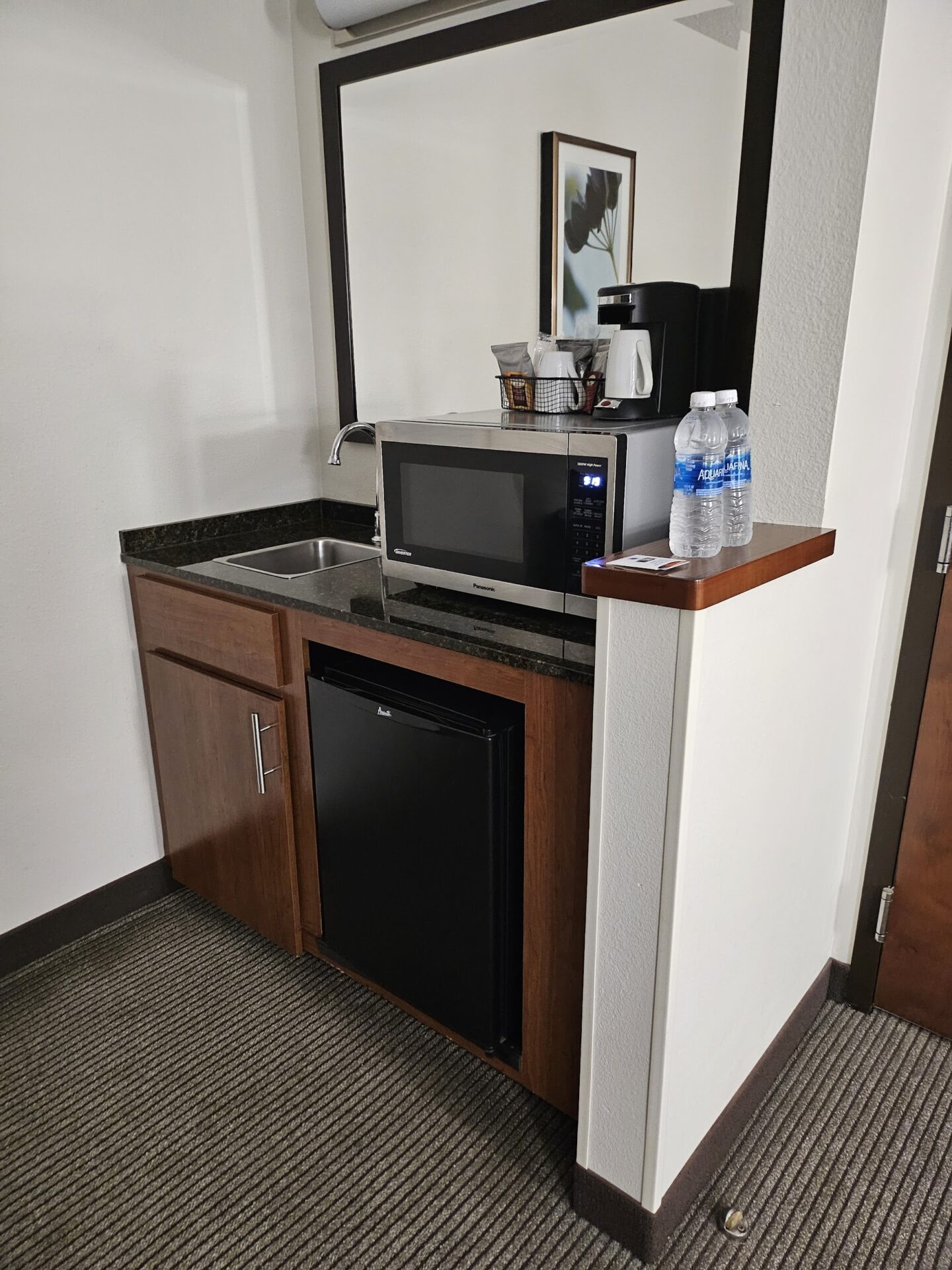 a small kitchen with a microwave and a small refrigerator