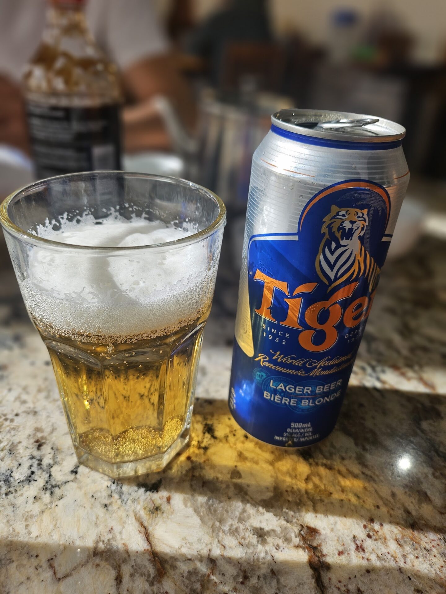 a can of beer next to a glass of beer