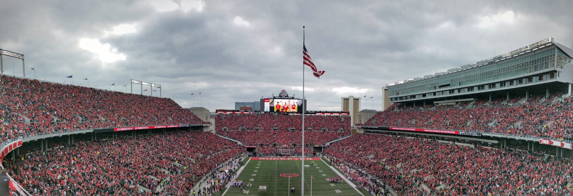 a football stadium with a flag pole and people in the background