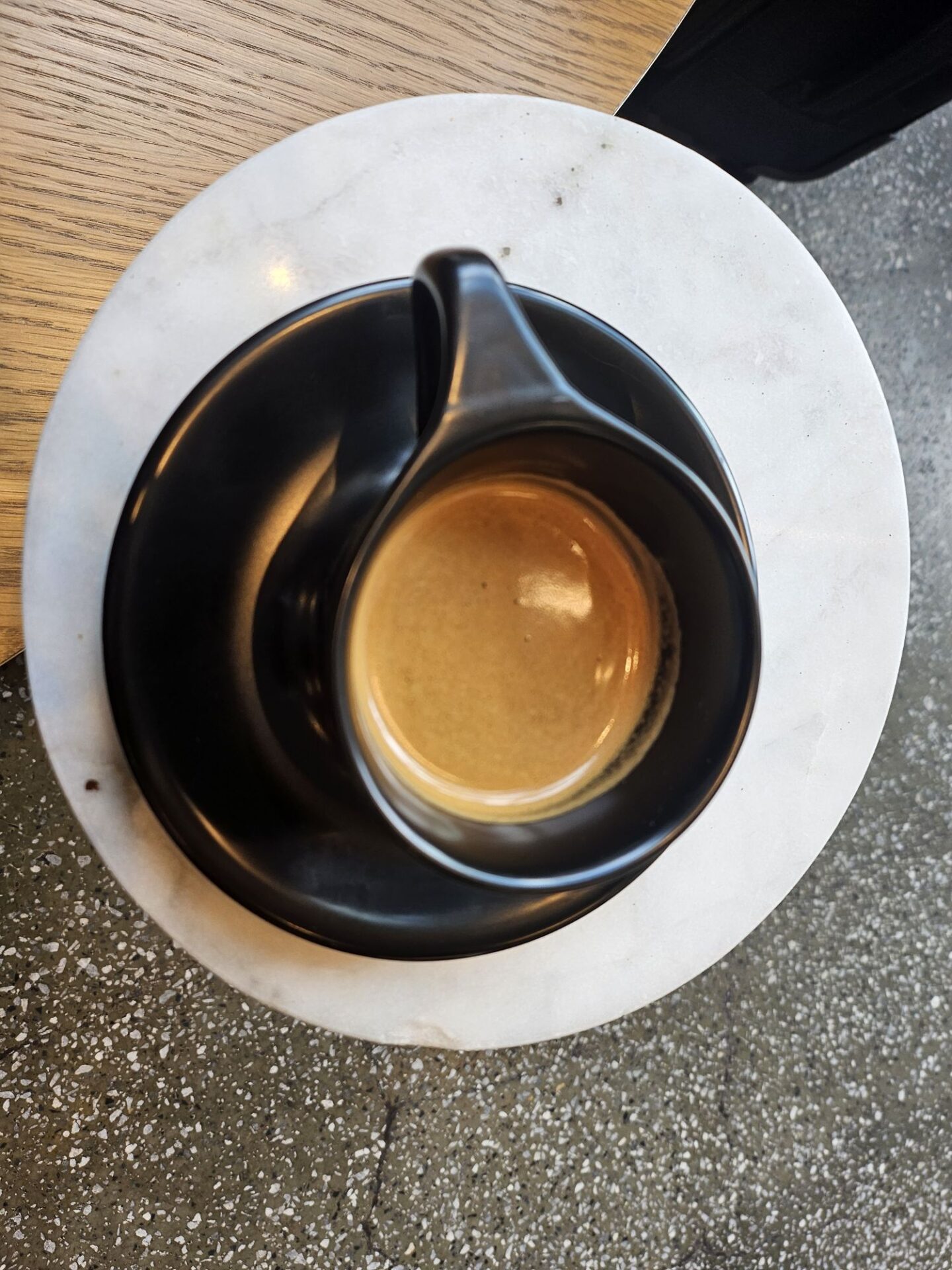 a black cup with a brown liquid in it