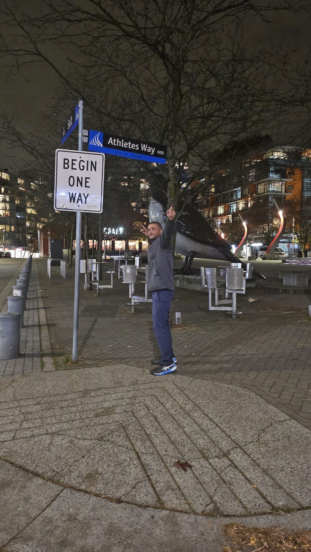 a man standing in front of a street sign