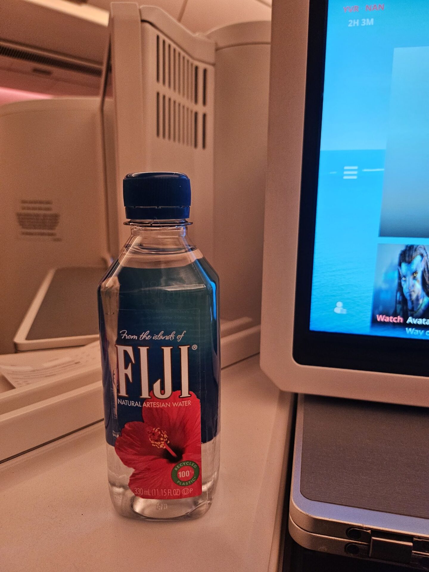 a bottle of water next to a computer