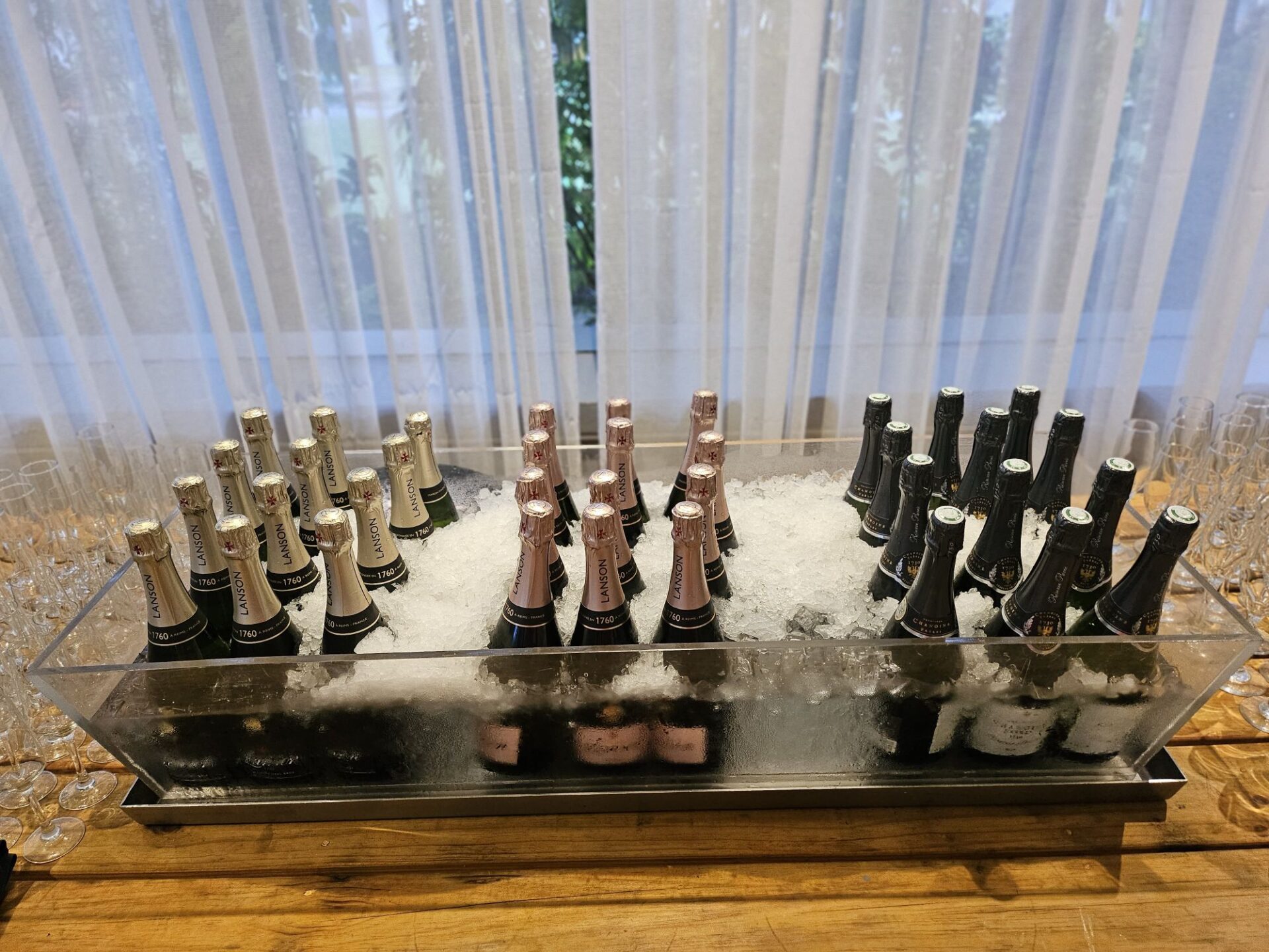 a group of champagne bottles in a container with ice