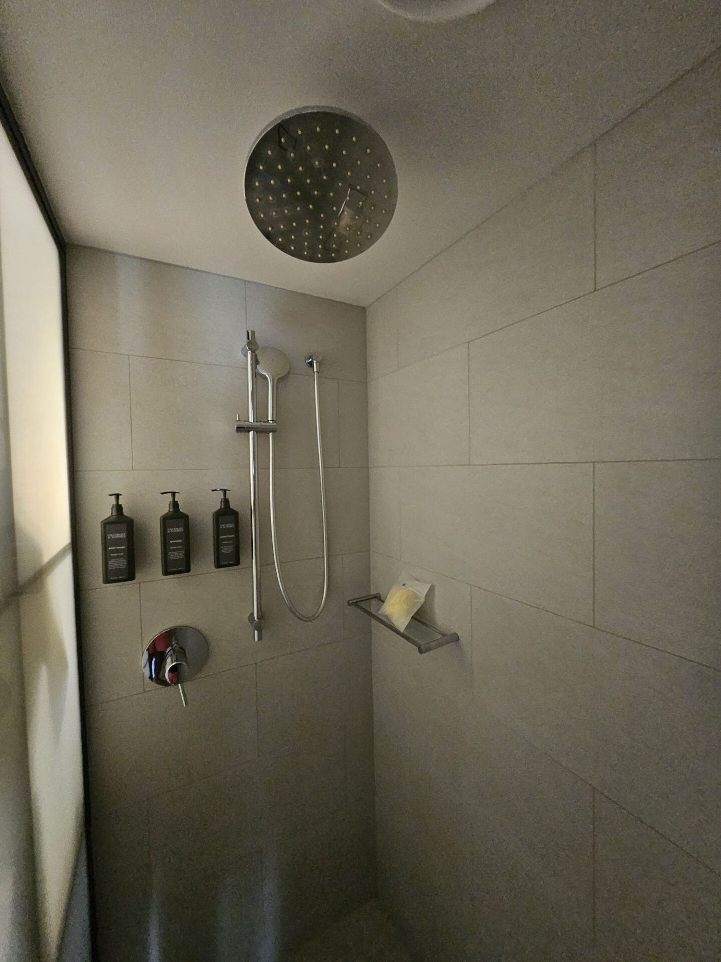 a shower with a shower head and soaps