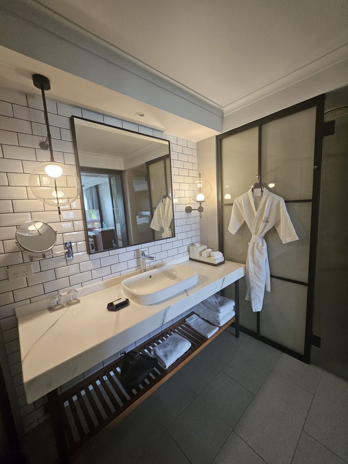 a bathroom with a white bathrobe and a mirror