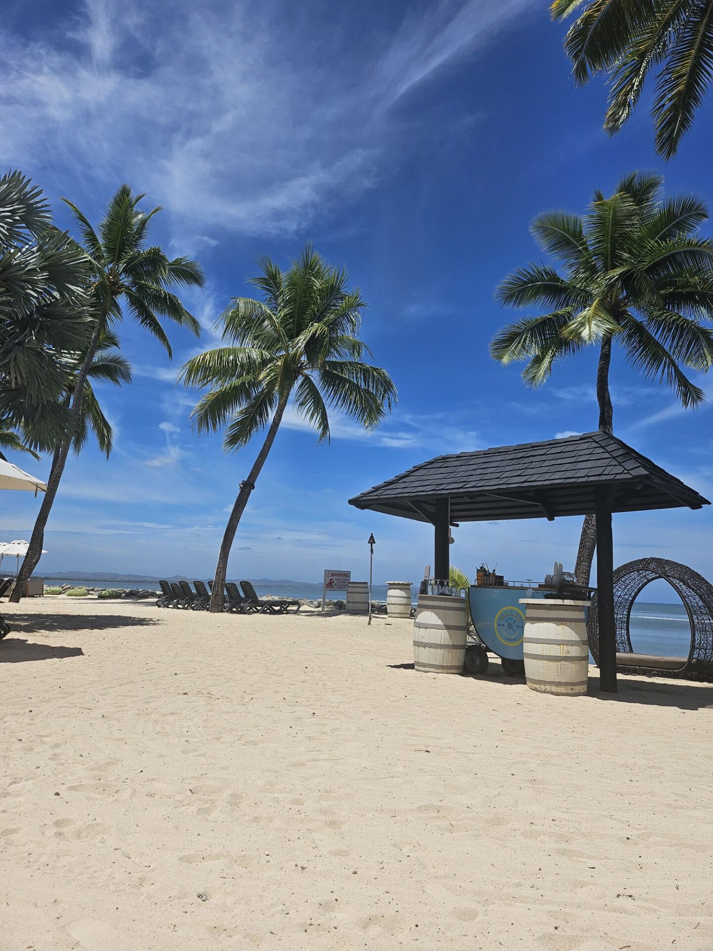 a beach with palm trees and a gazebo