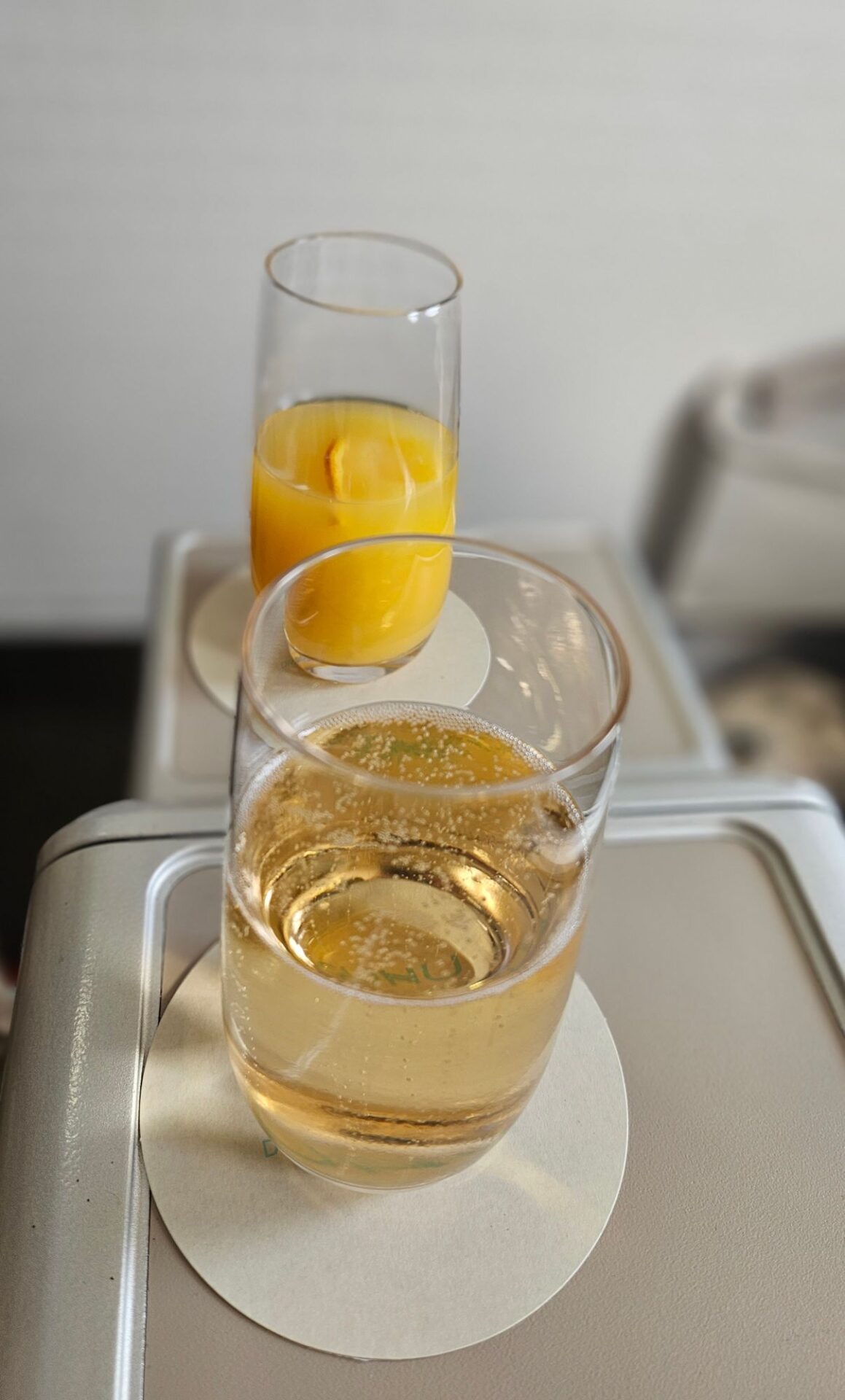 a glass of liquid and a glass of orange juice on a tray