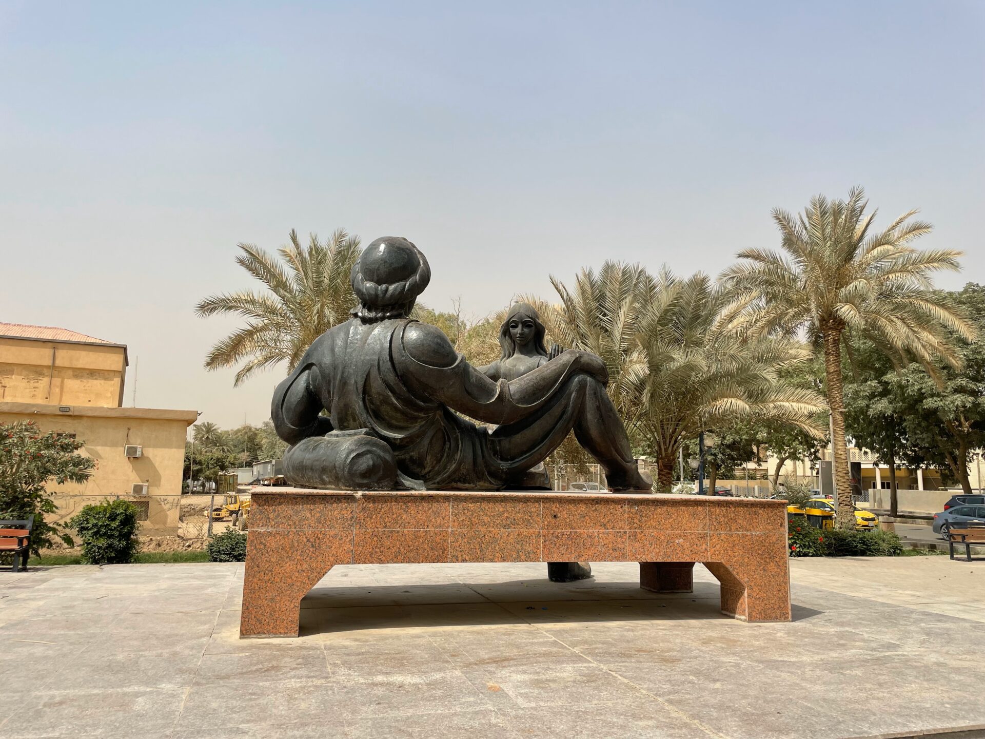 a statue of a man and a woman sitting on a bench