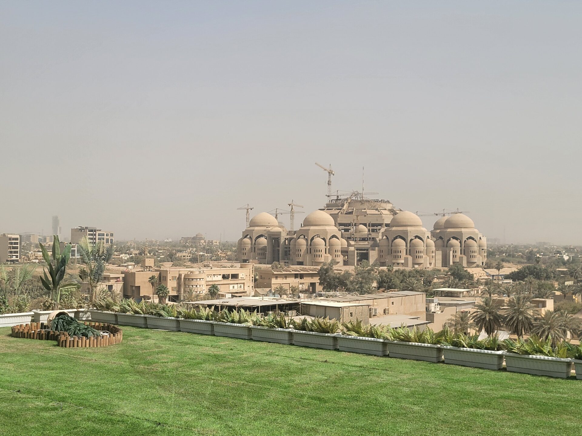 a large building with domes and a green lawn