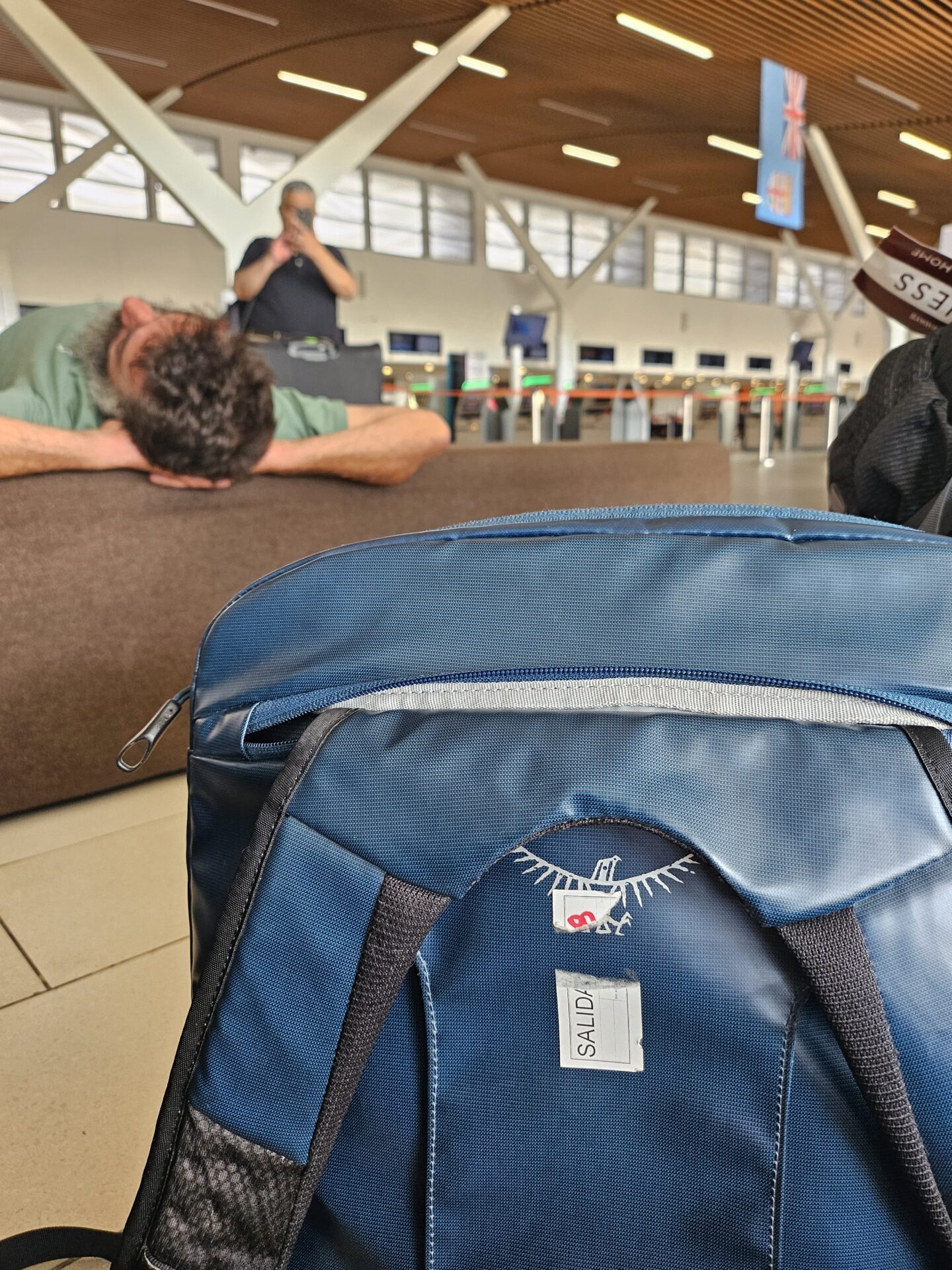a man sleeping on a couch in an airport