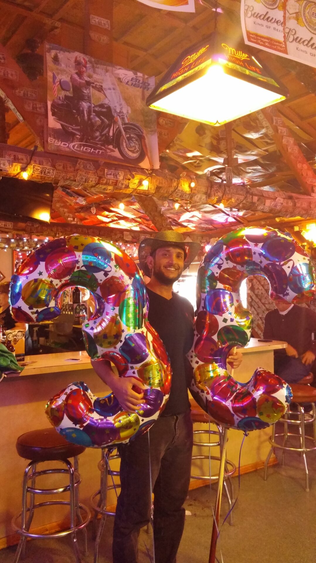 a man holding balloons in the shape of three