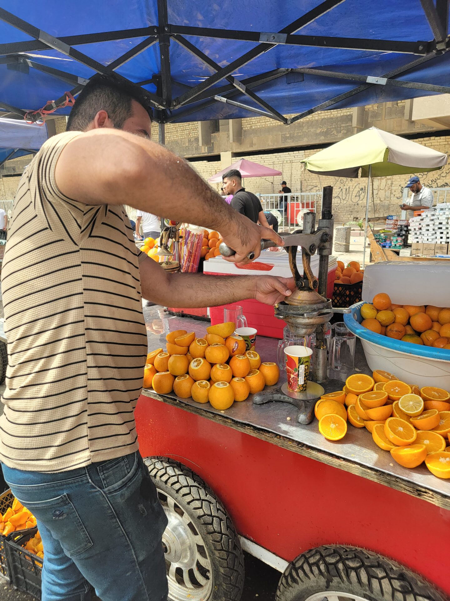 a man making orange juice at a fruit stand