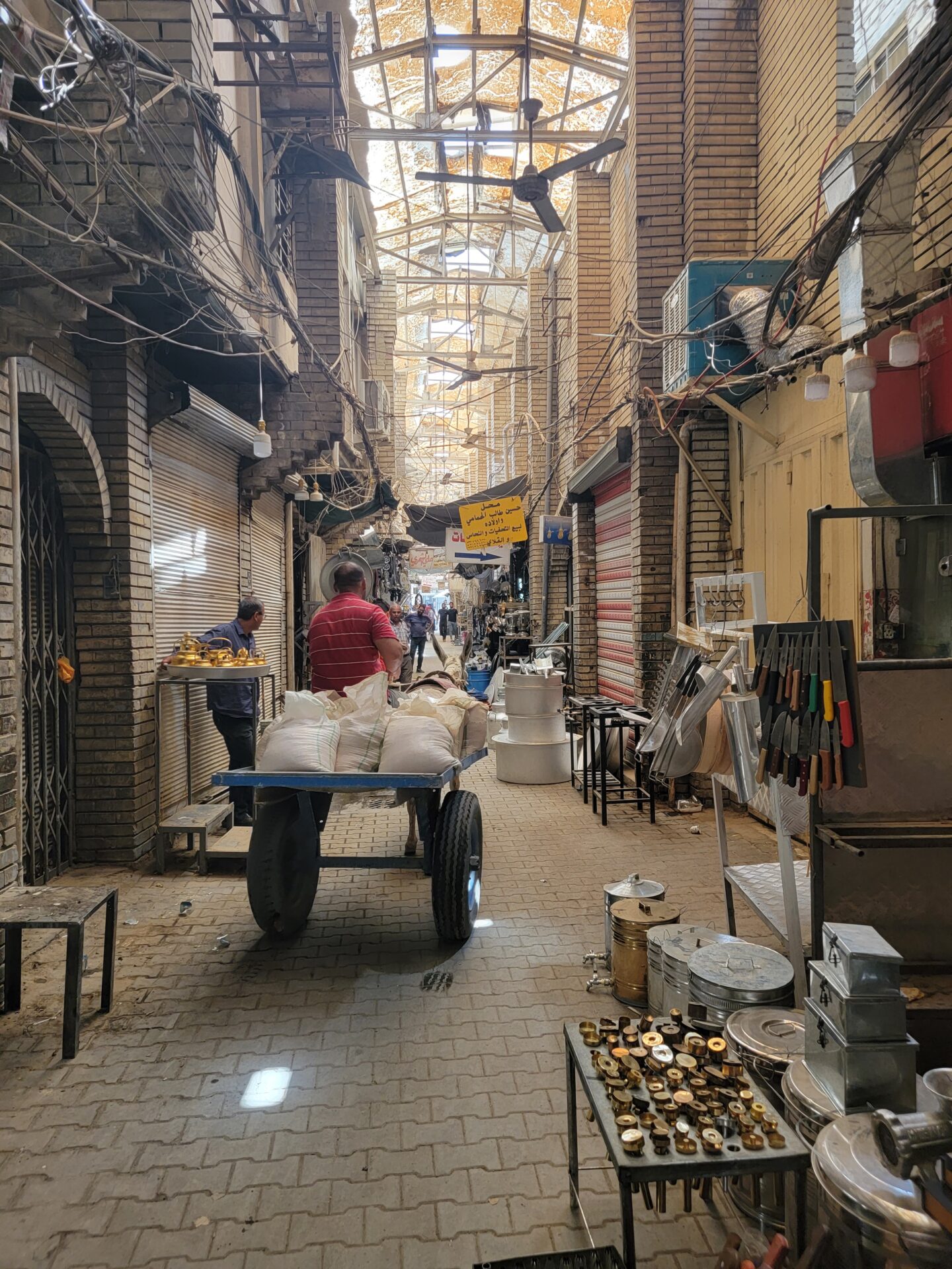 a man pushing a cart in a brick alley