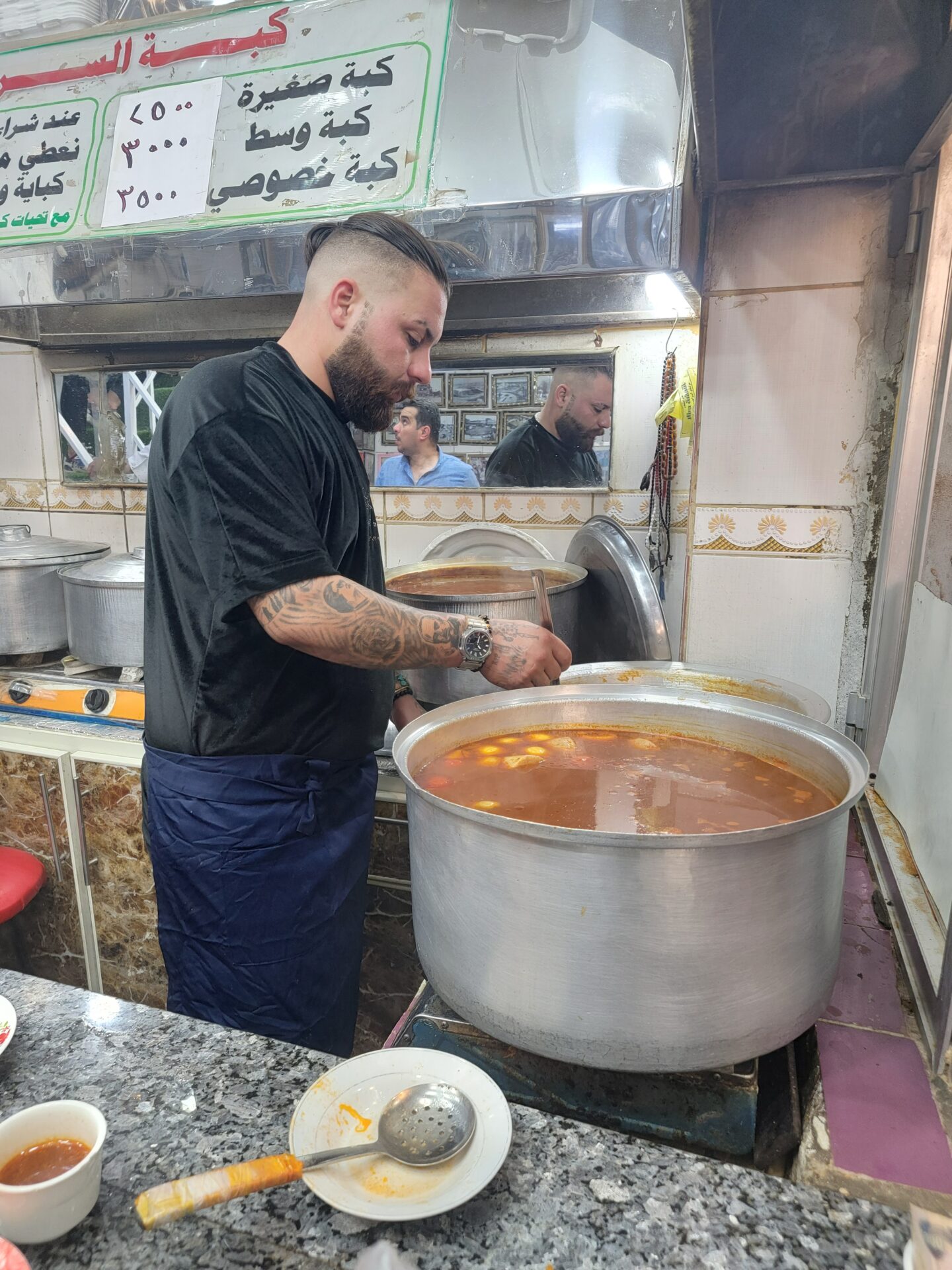 a man cooking in a large pot