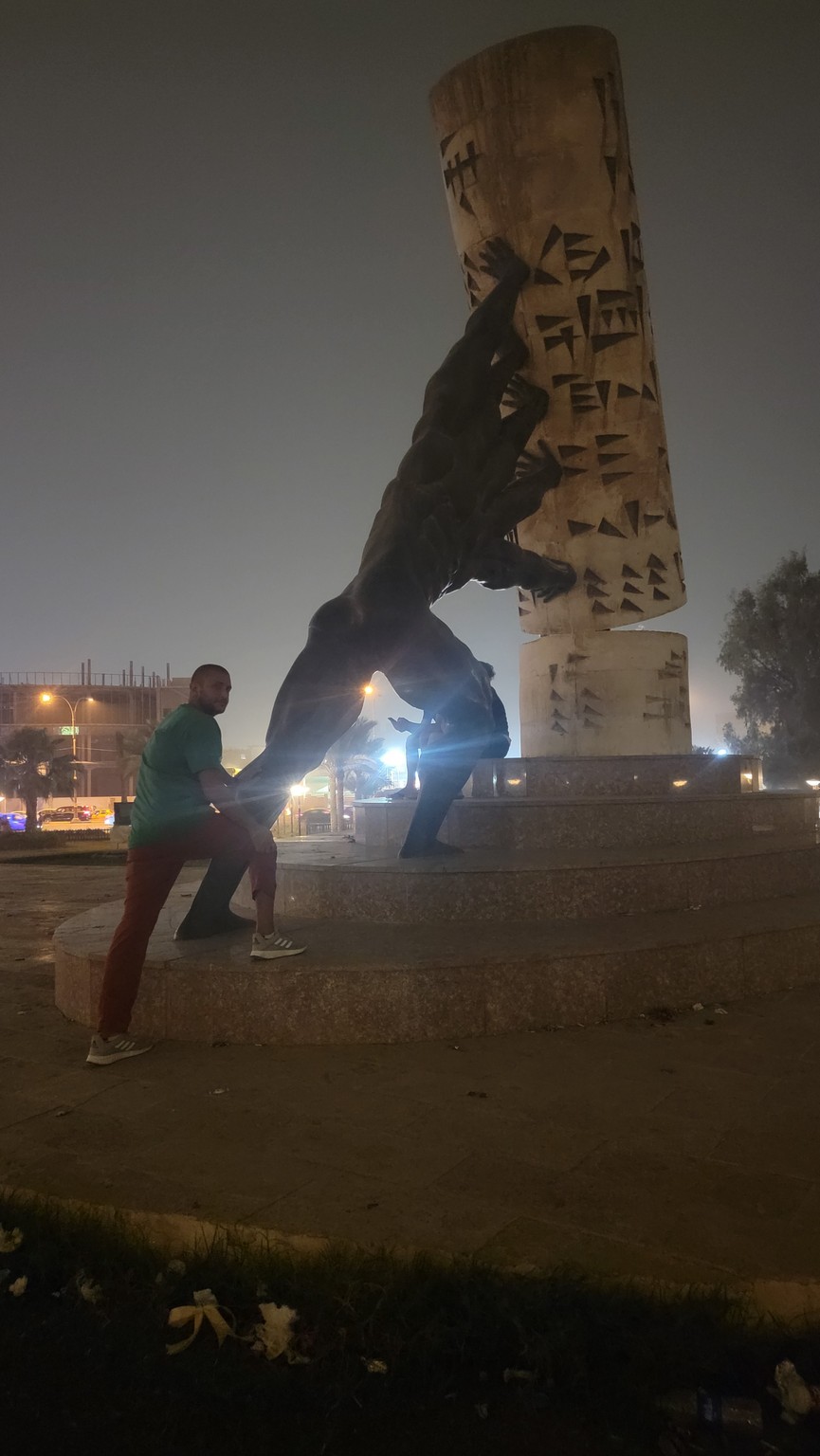 a man posing for a picture with a statue