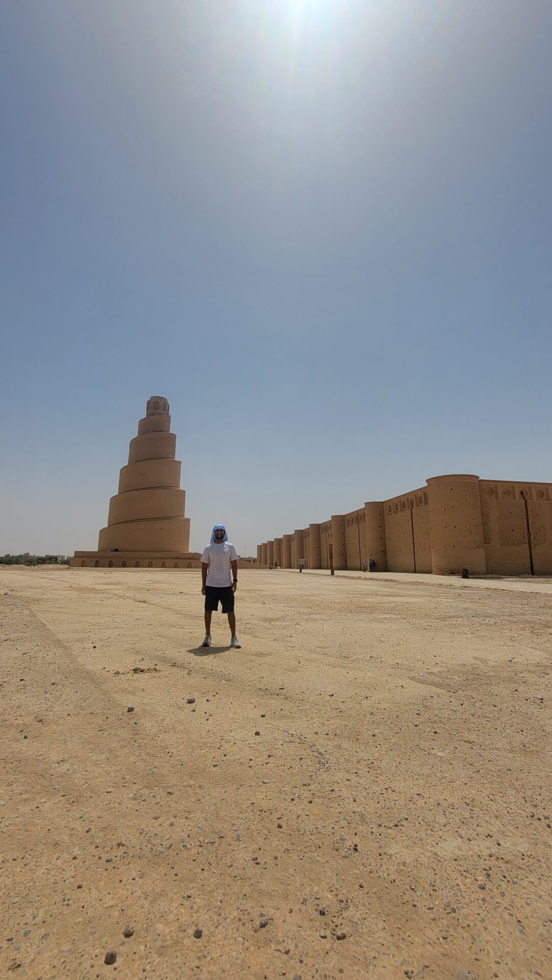 a man standing in a desert with a tall tower
