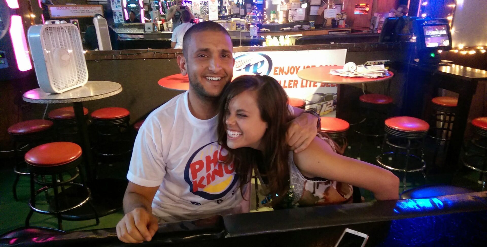 a man and woman sitting at a bar