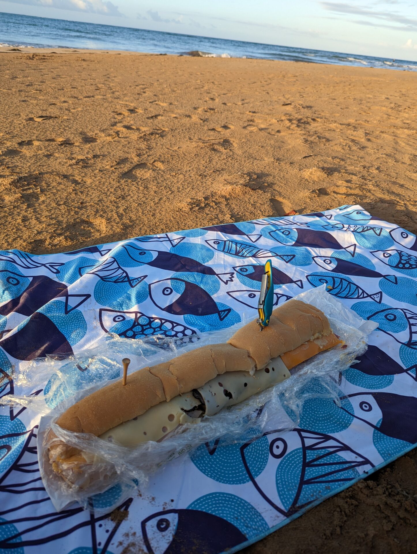 a sandwich on a towel on a beach