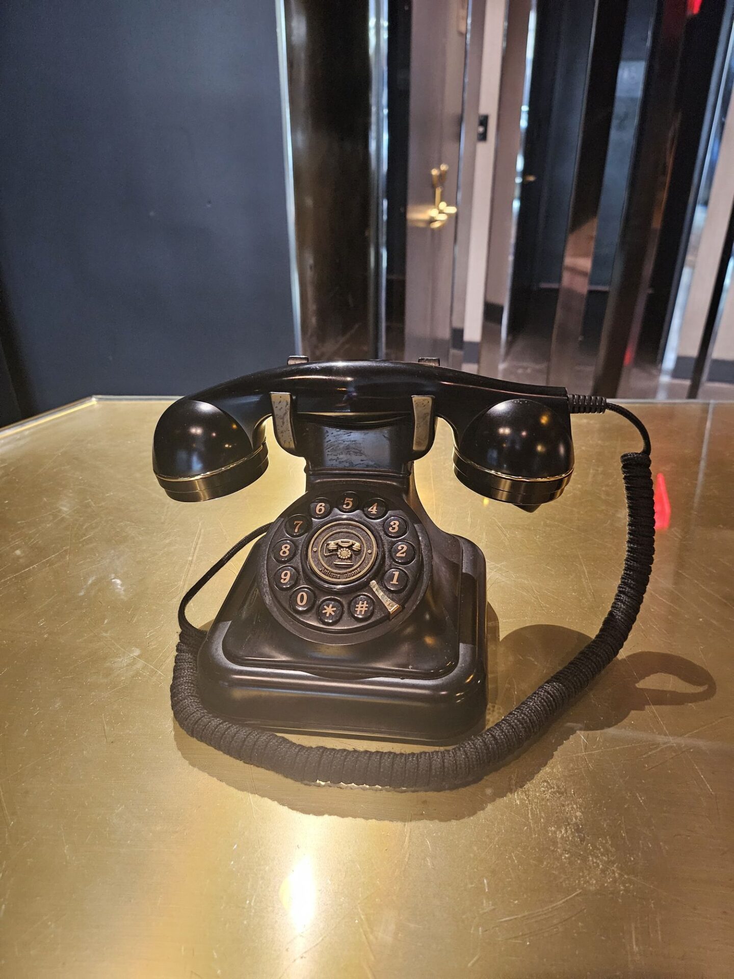 a black telephone on a gold table