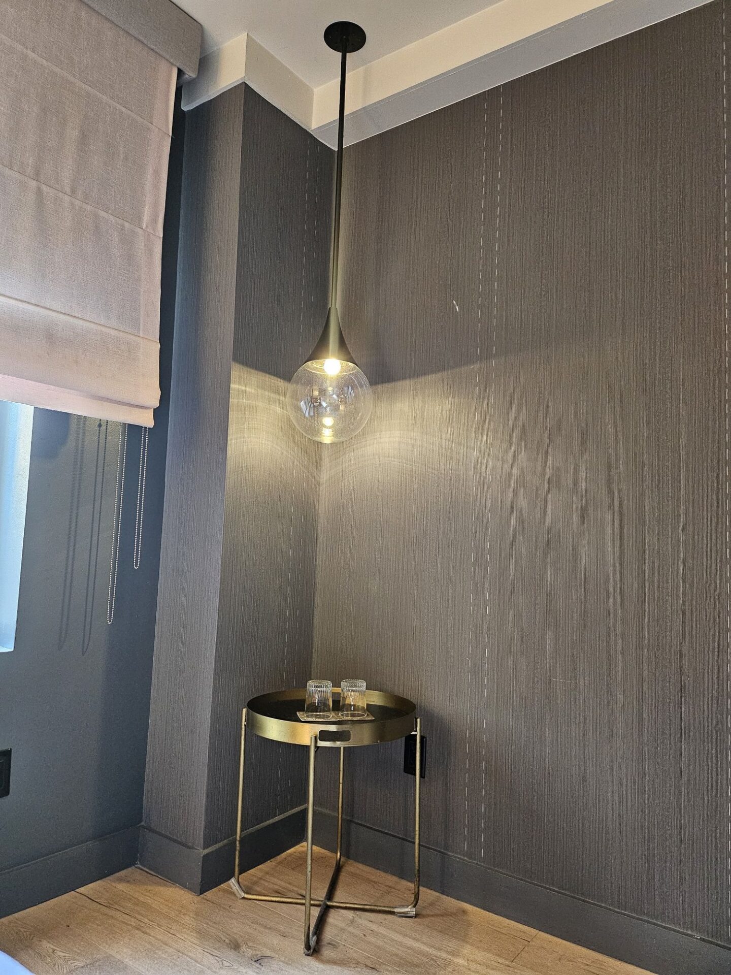a small table with a glass light fixture from the ceiling