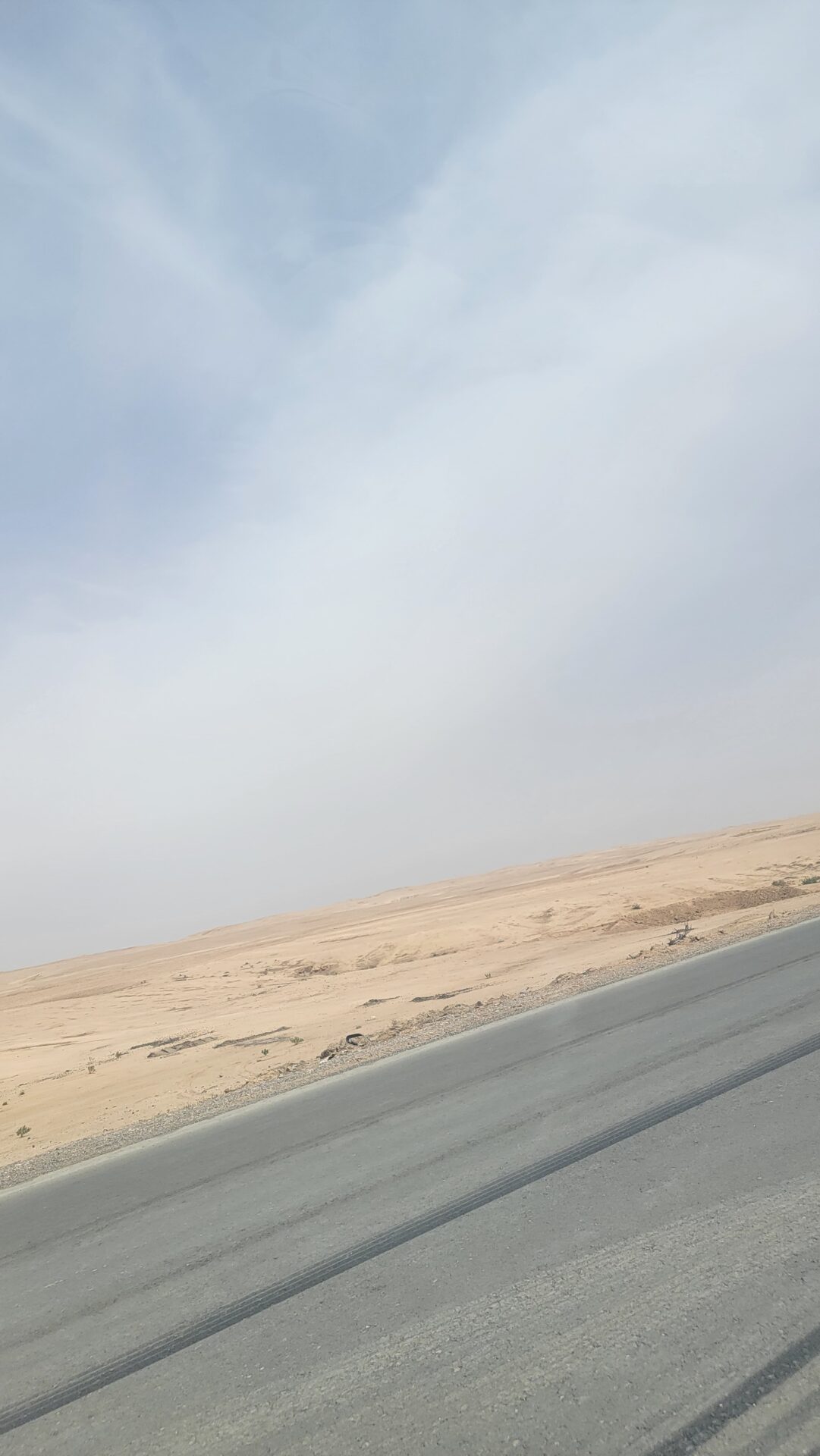 a road with a sandy landscape