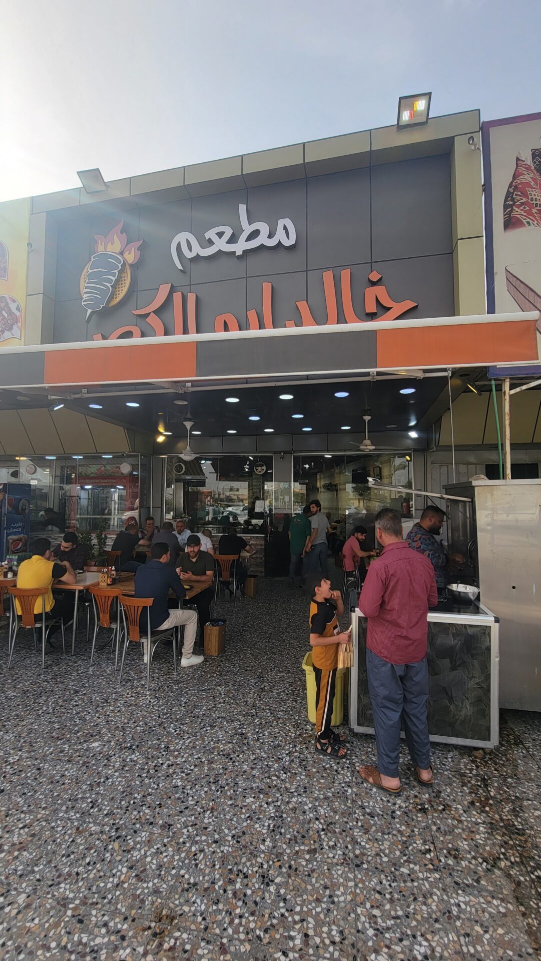 a group of people sitting at tables outside a restaurant