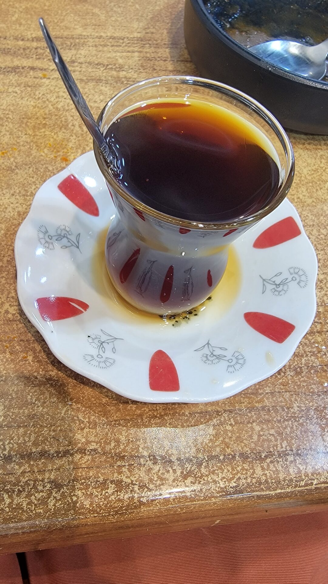 a glass cup with liquid on a plate