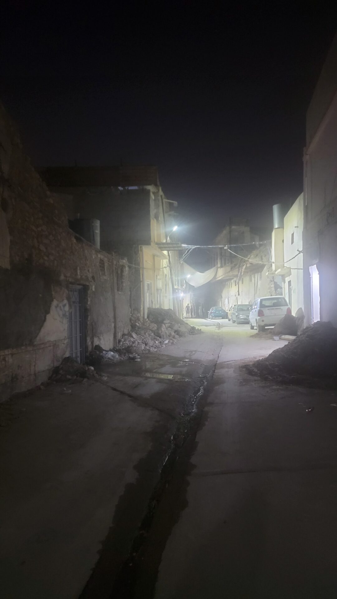 a street with cars and buildings at night