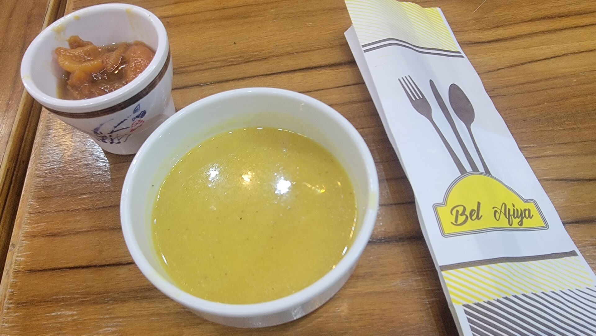 a bowl of soup next to a bowl of sauce