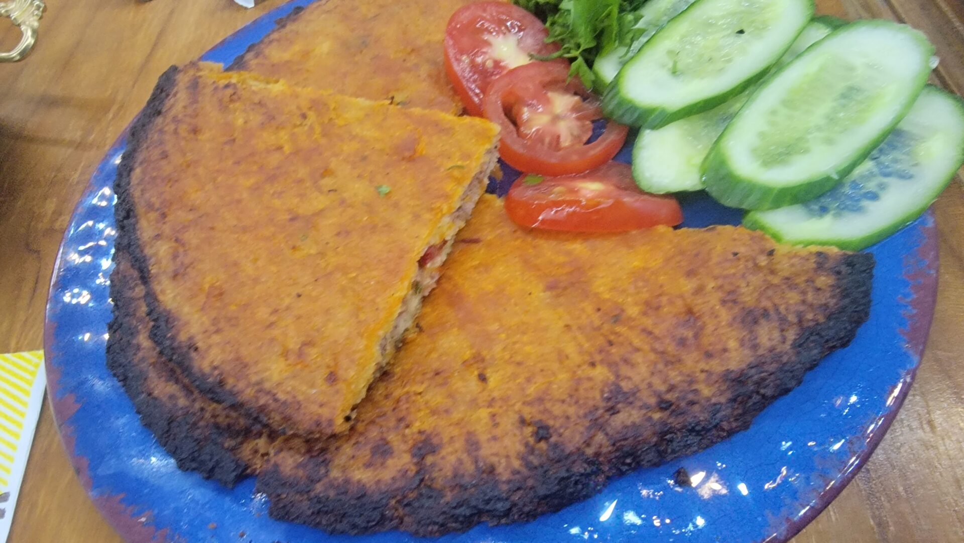 a plate of food with tomatoes and cucumbers