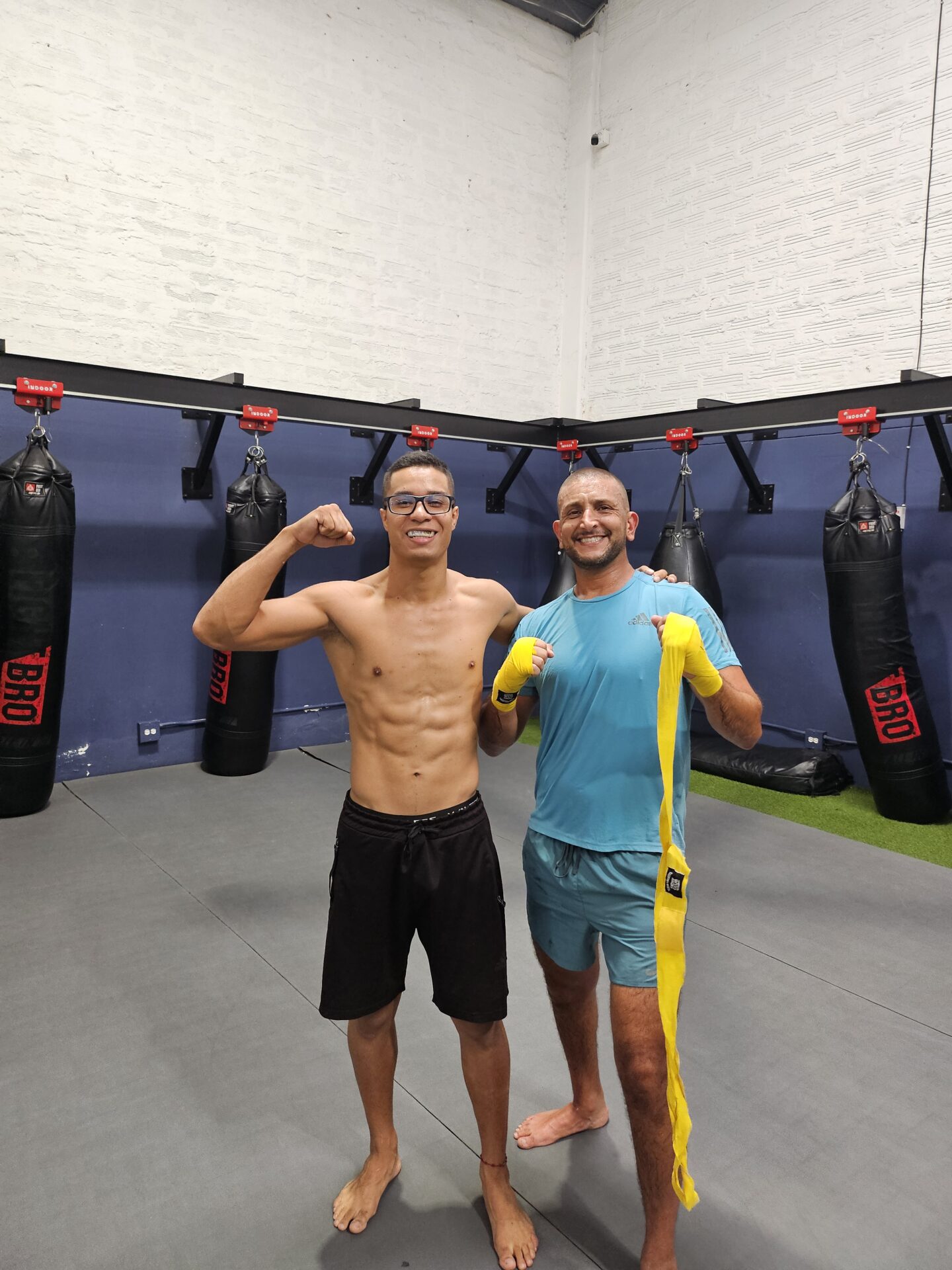 a man standing next to another man in a gym