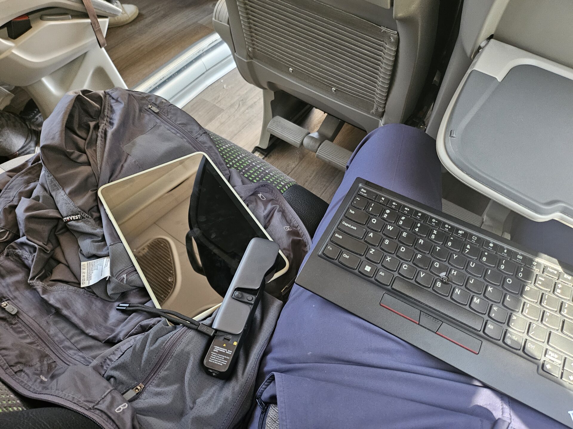 a laptop and phone on a seat