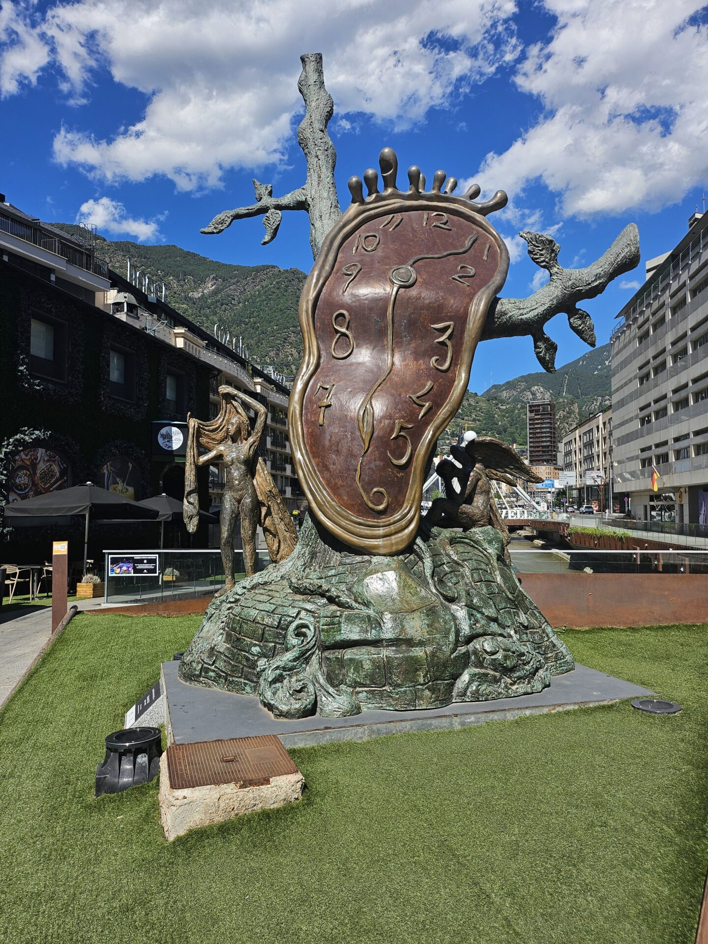 a statue of a clock on a tree in a city