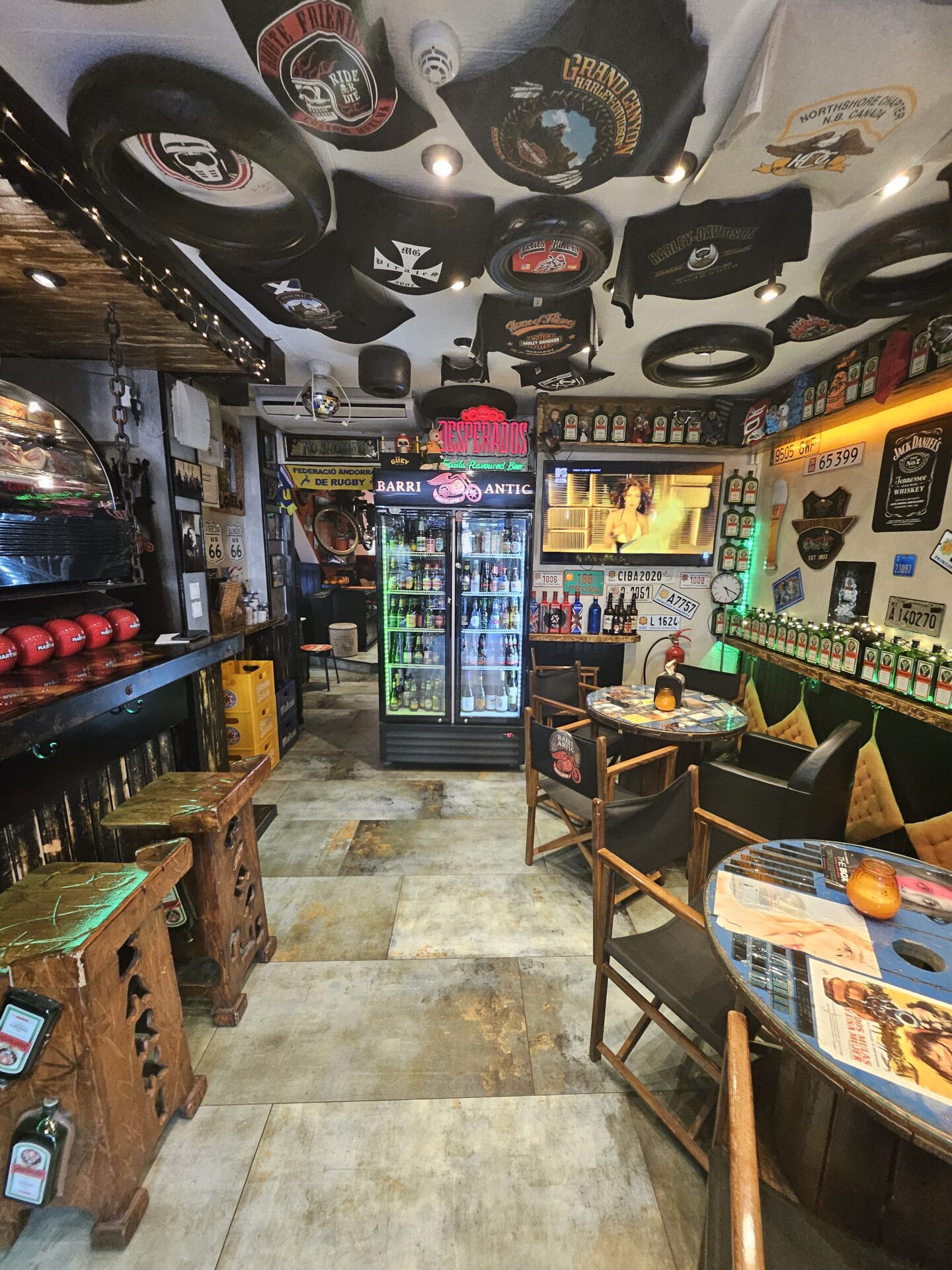 a room with tables and chairs and a fridge with beer bottles