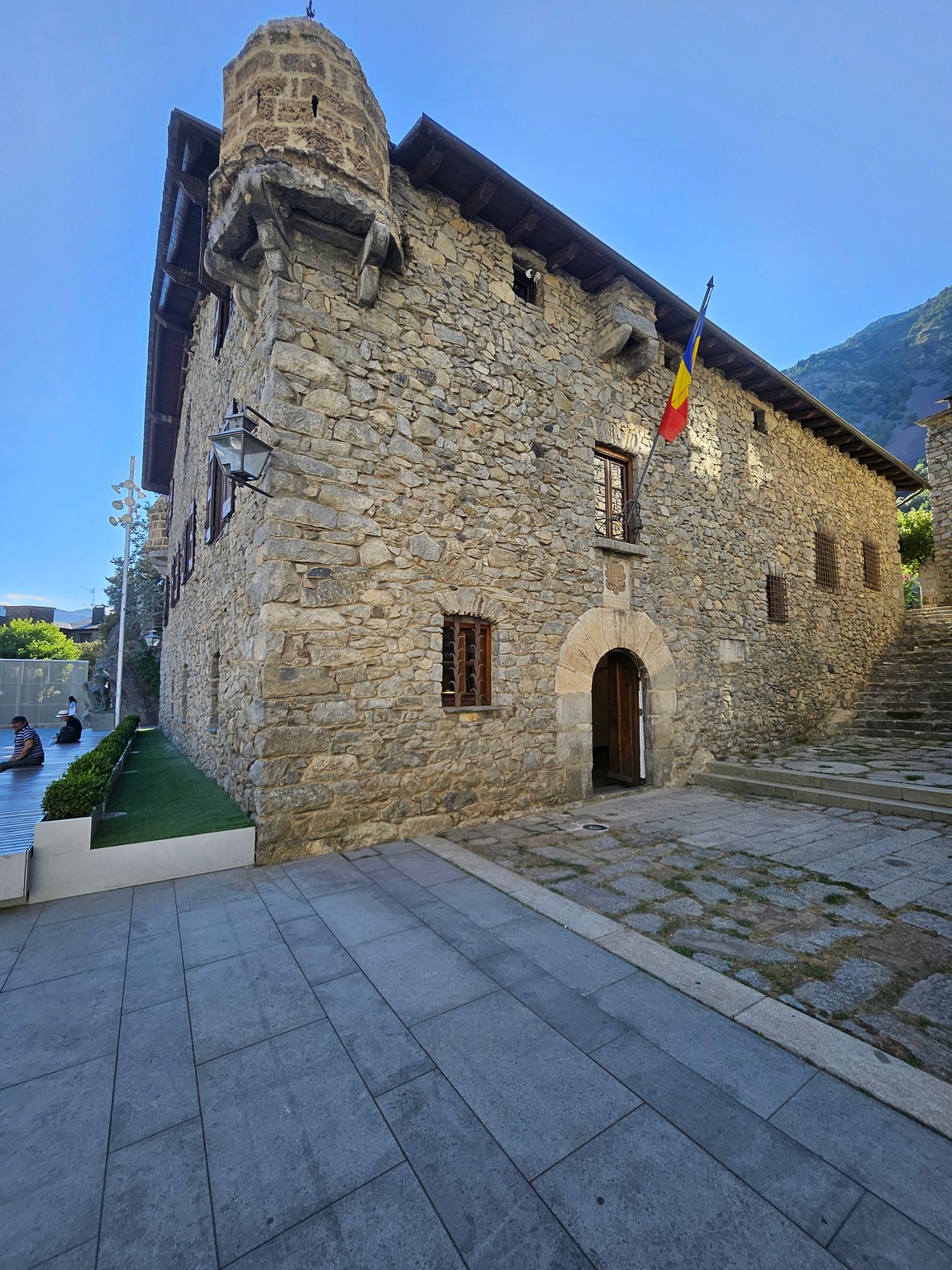 a stone building with flags on the roof