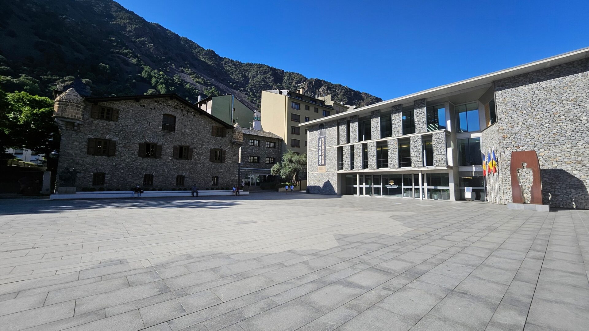 a building with a stone courtyard and a mountain in the background