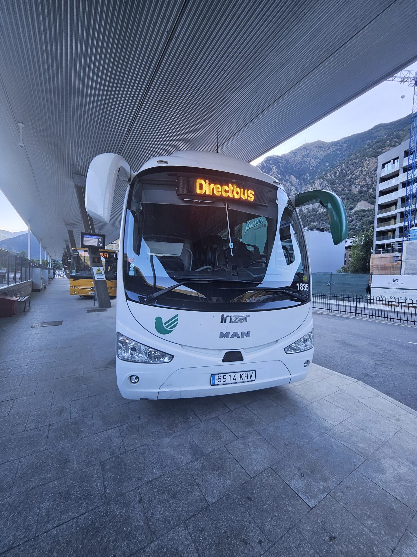 a white bus parked under a bridge