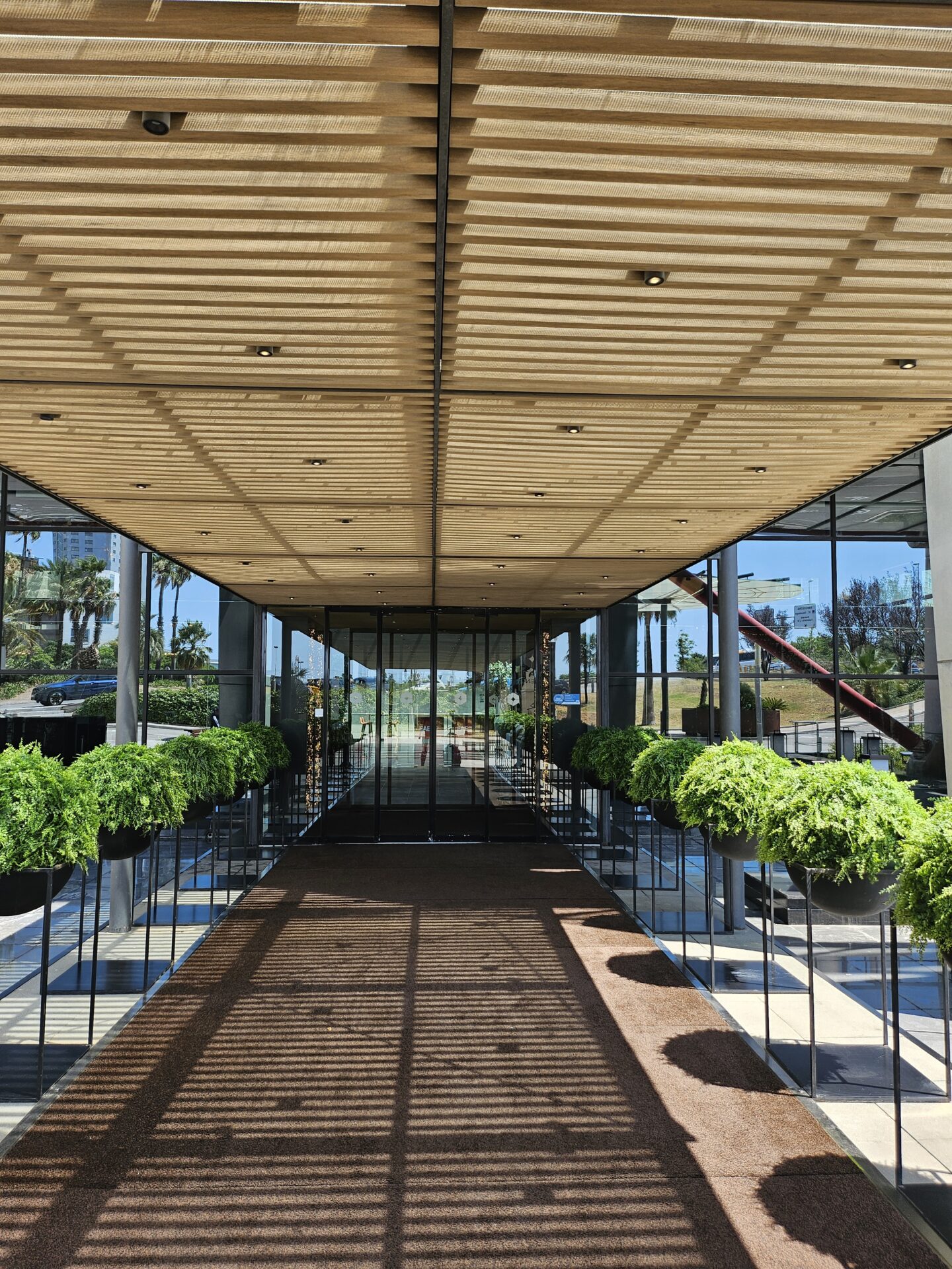 a glass building with plants in pots