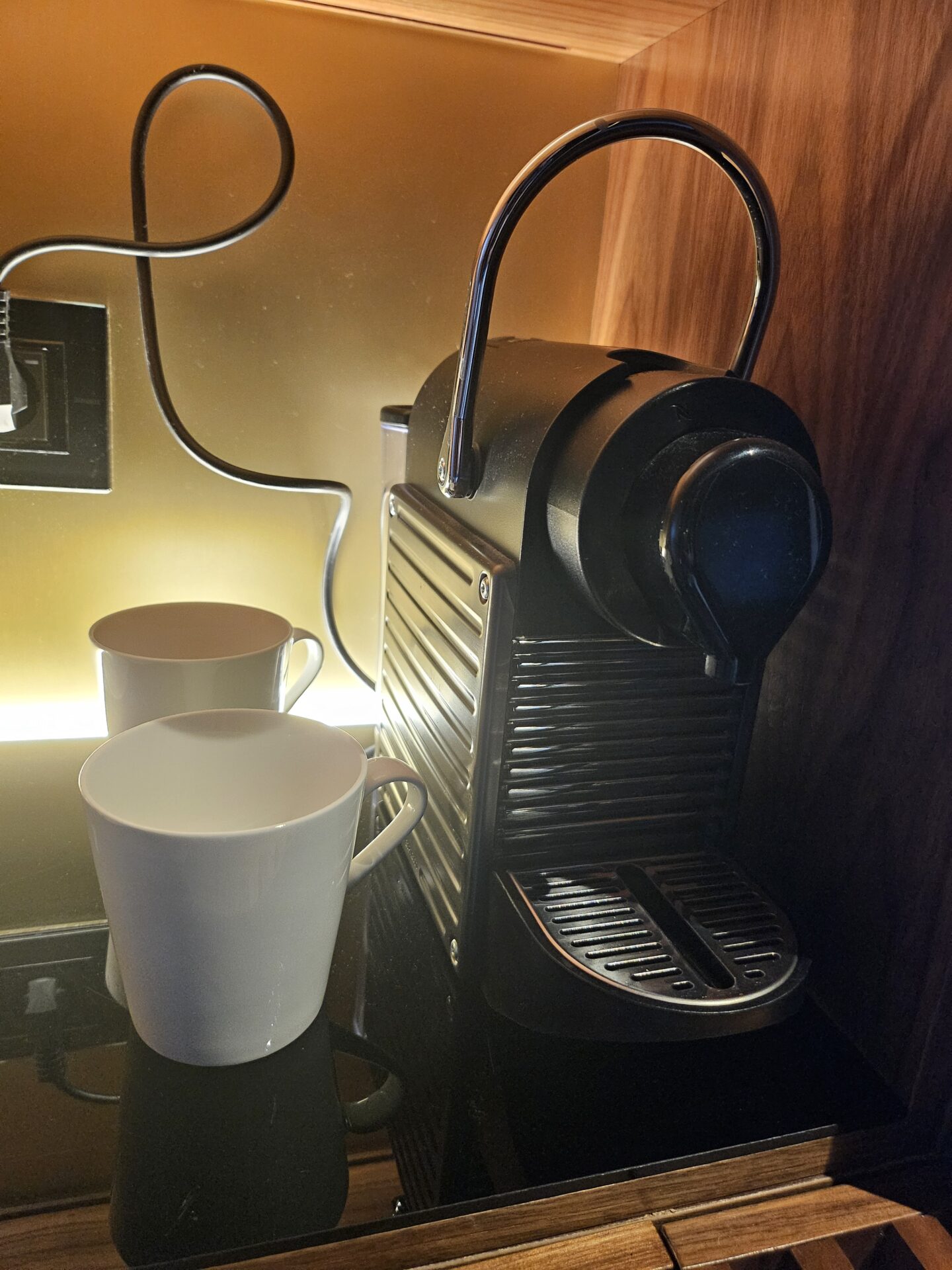 a coffee machine next to a white mug