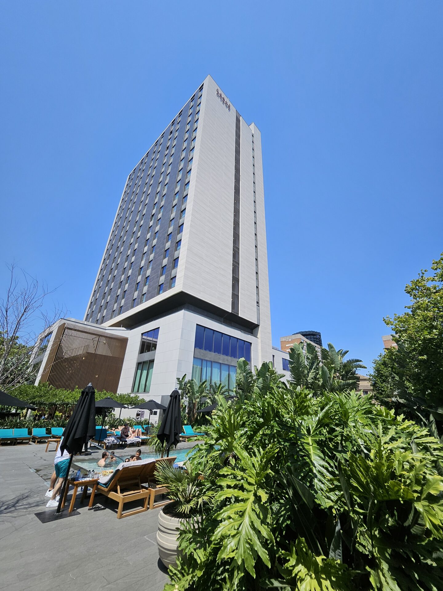 a building with a pool and umbrellas