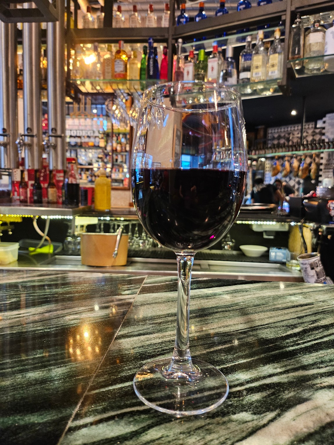 a glass of wine on a bar counter