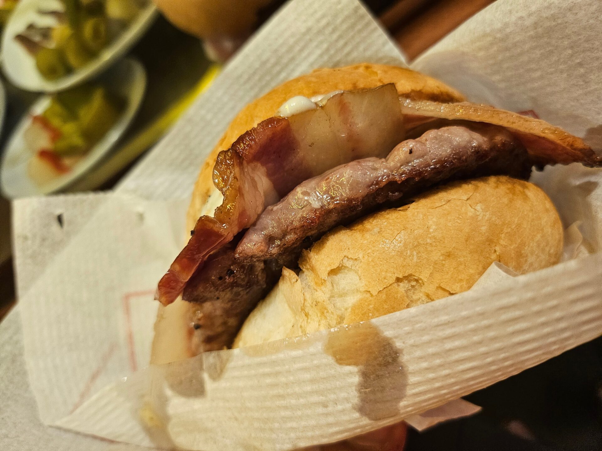 a bacon burger on a napkin