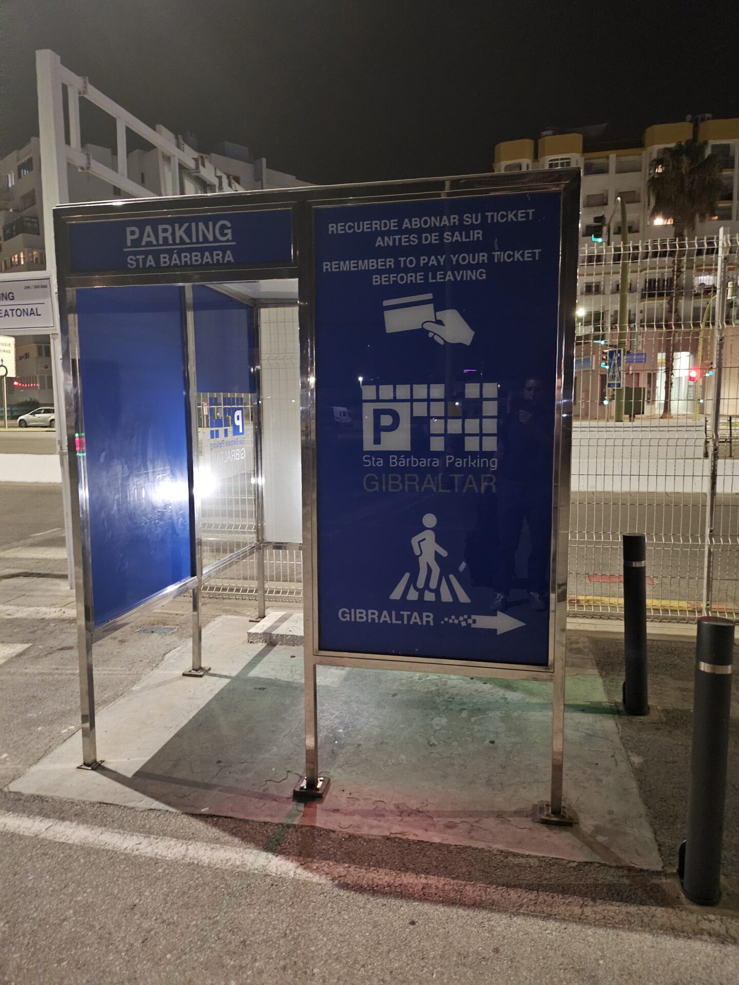 a blue sign on a sidewalk