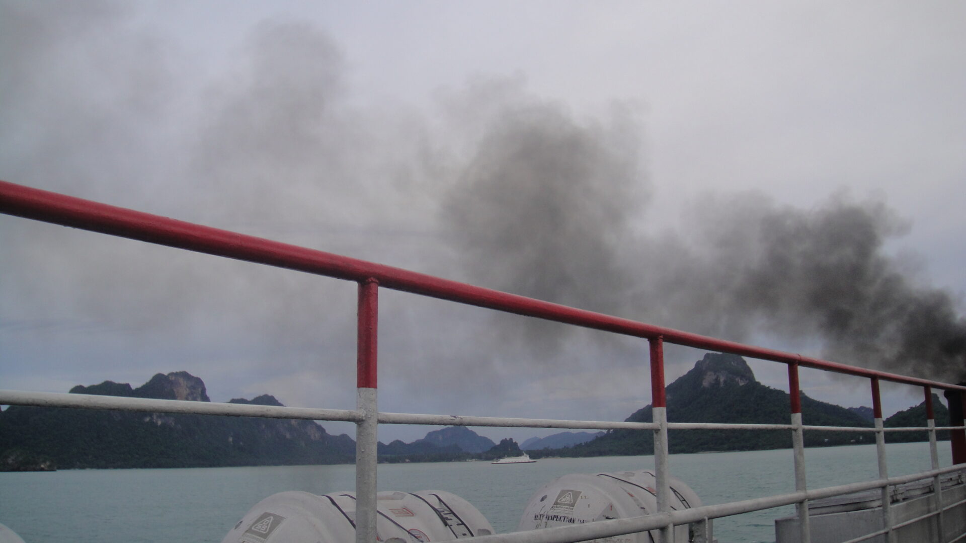 a railing with a red and white railing and a black smoke coming out of it