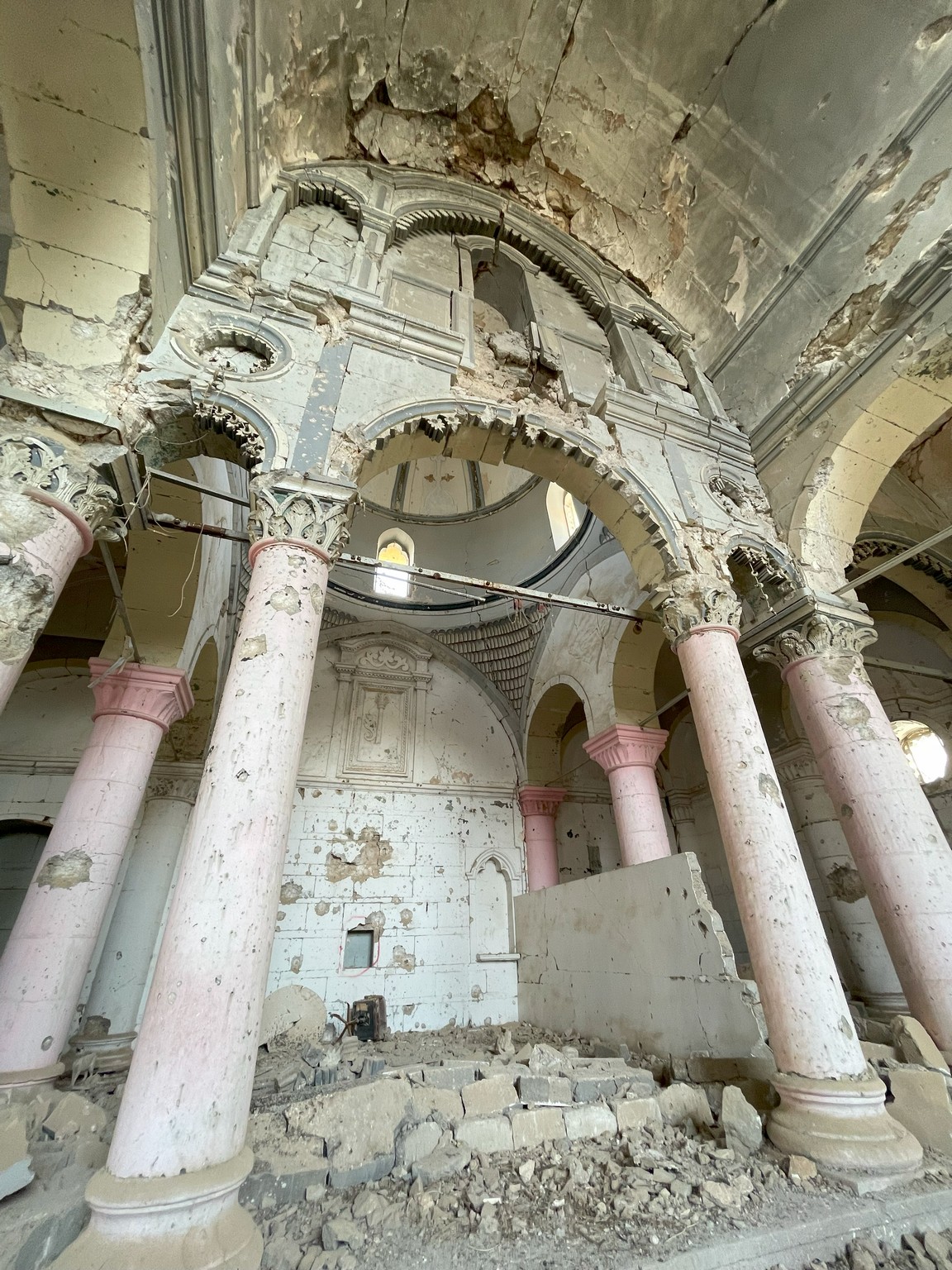 a ruined building with pink pillars