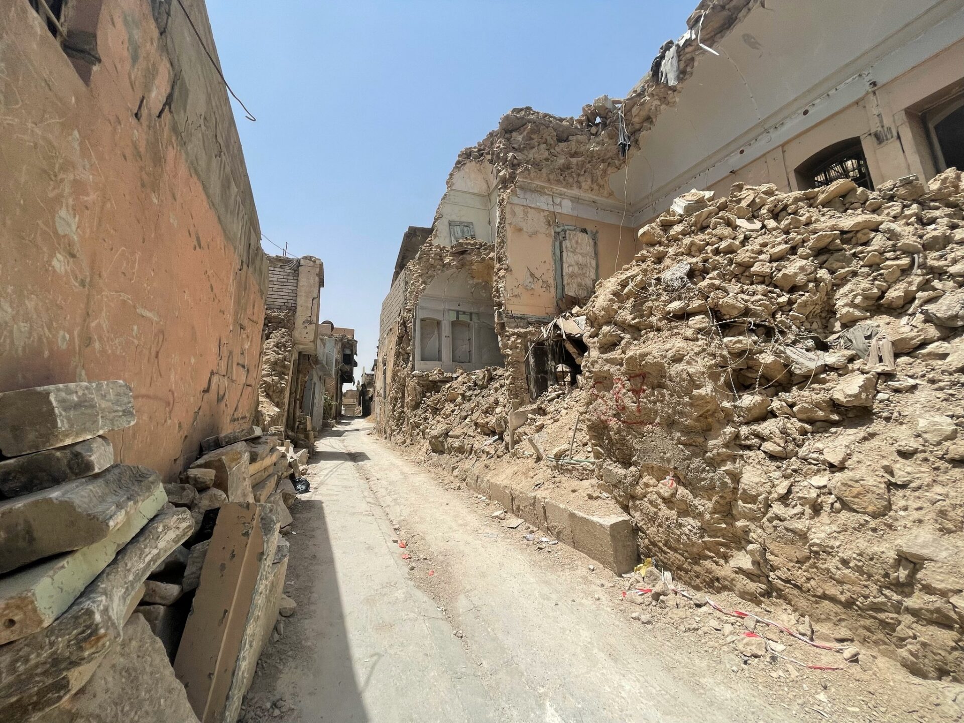 a dirt road with rubble on the side of it