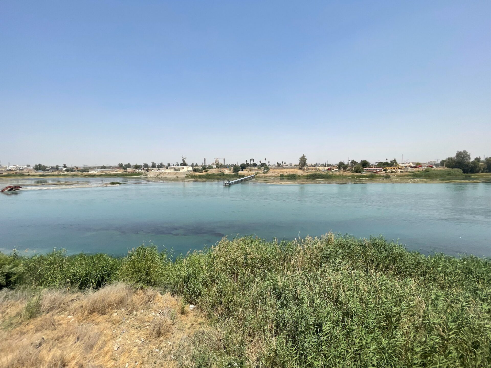 a body of water with a dock and buildings in the background