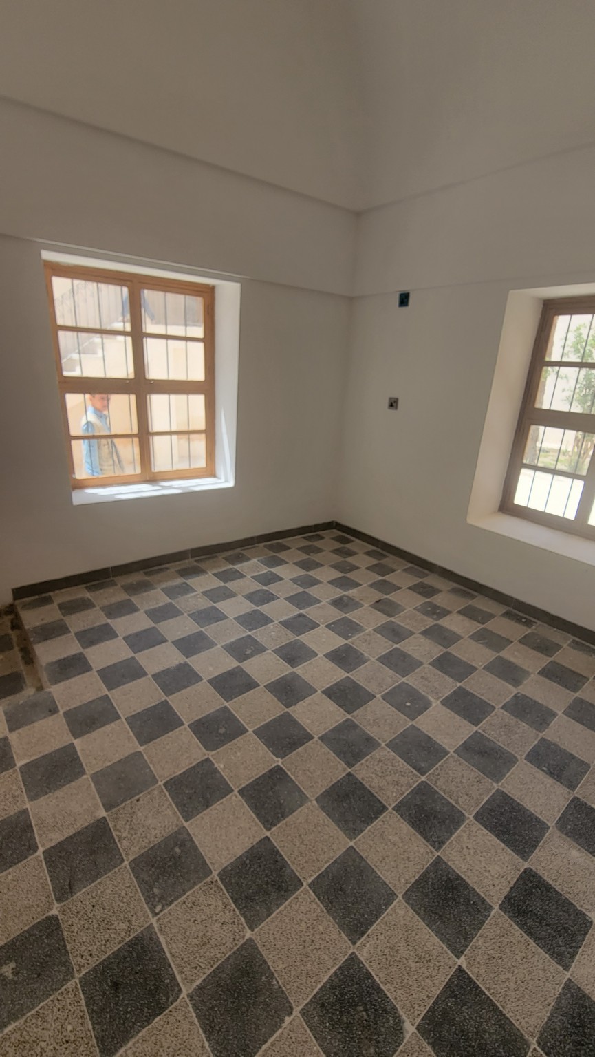 a room with a tile floor and windows