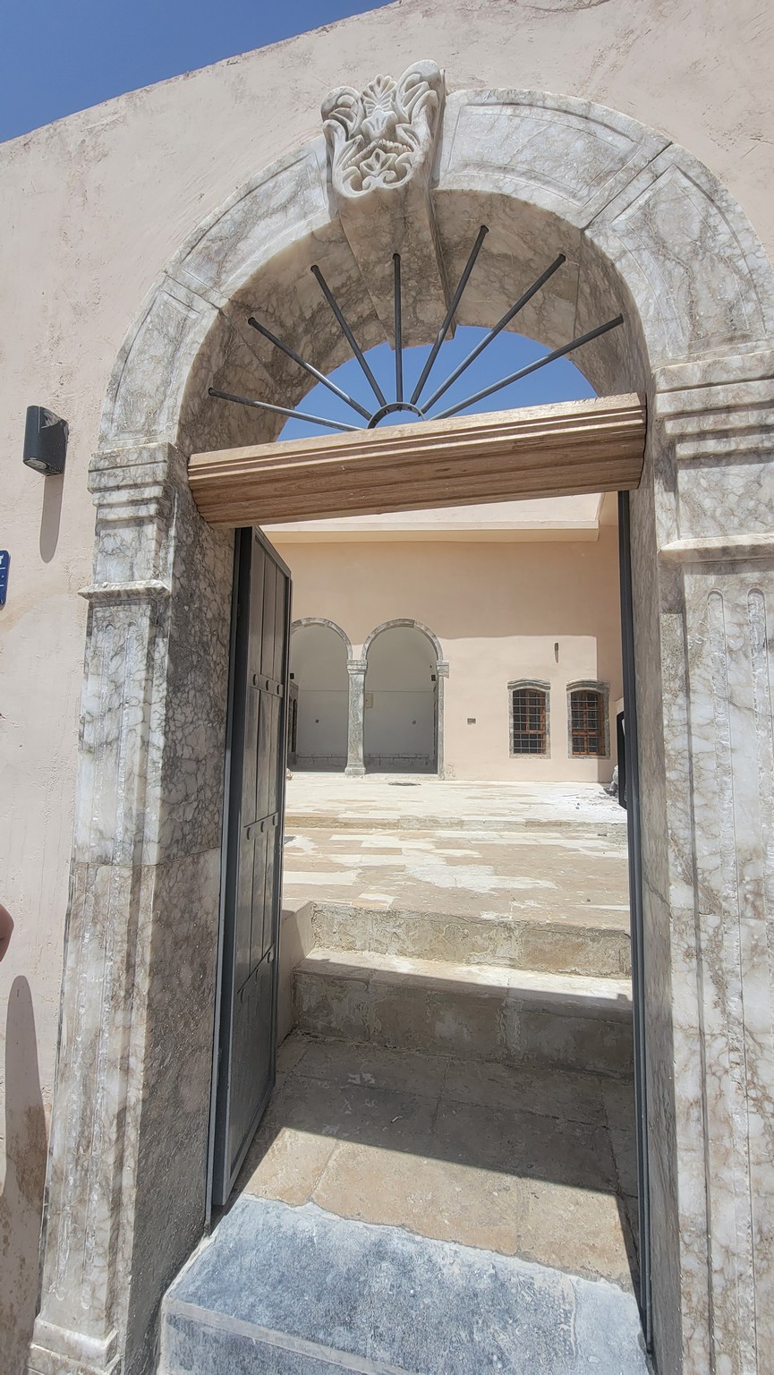 a stone archway with a door open